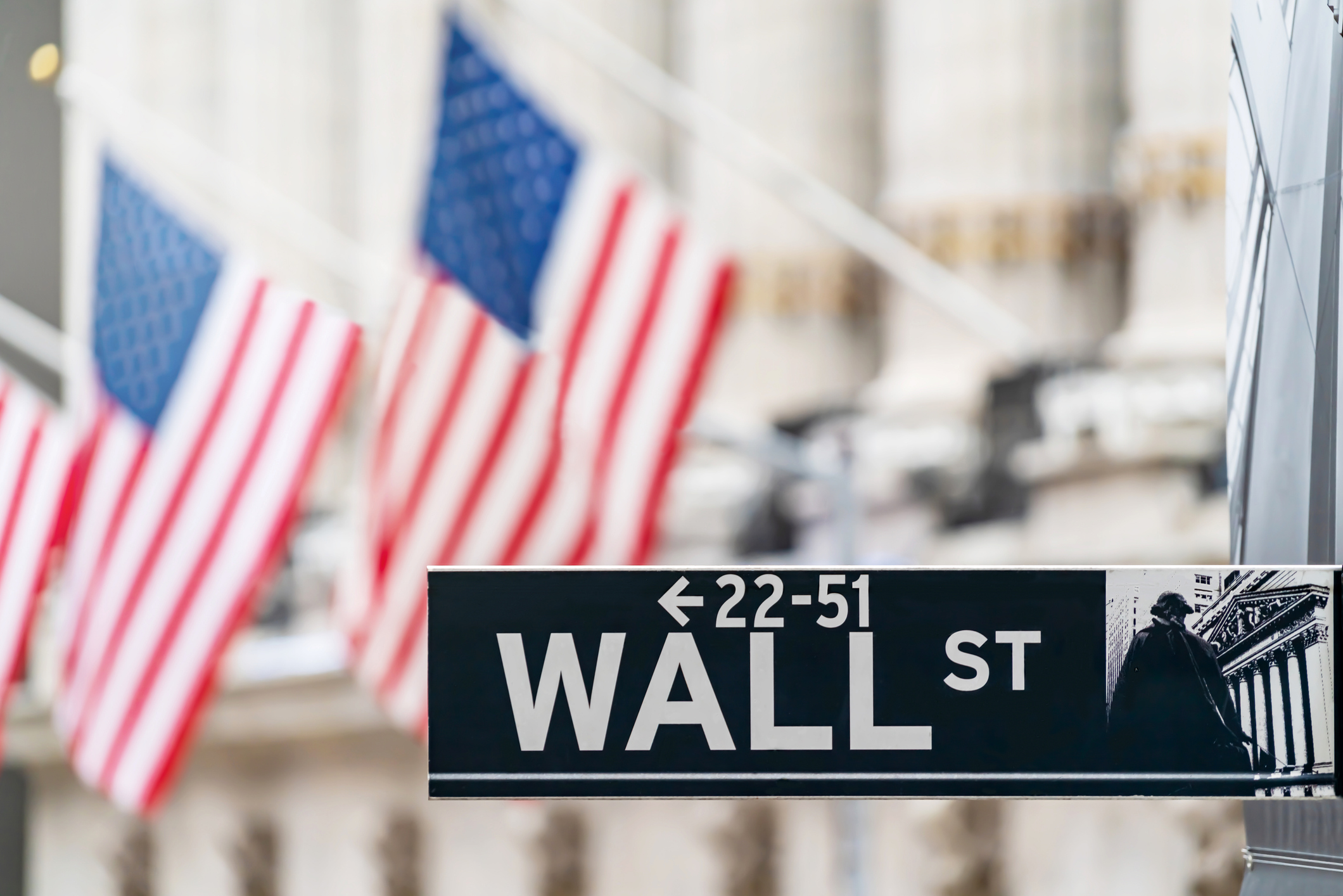 Wall Street sign with American flags in the background