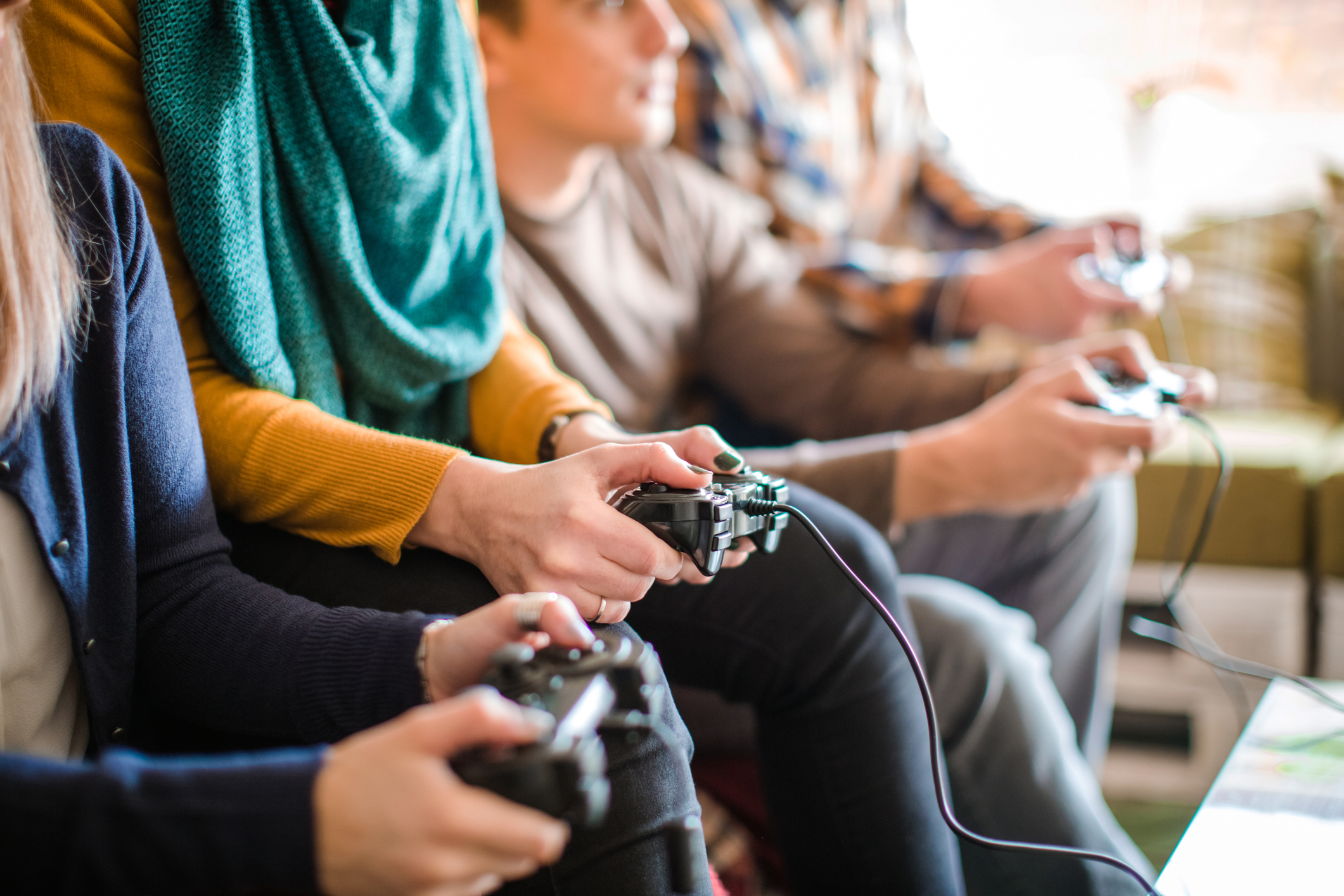 A row of seated teens holding video game controllers.