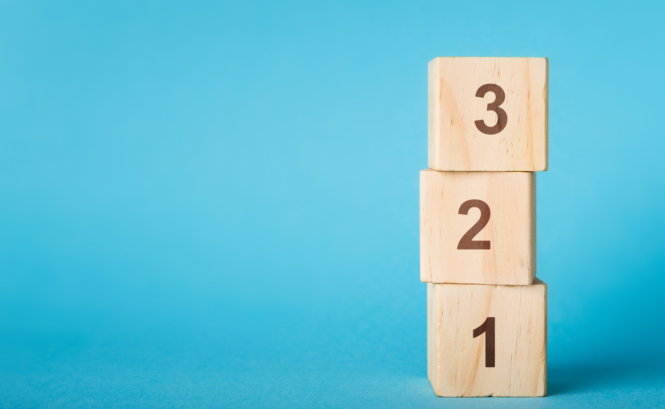 A stack of wooden blocks, labeled with descending numbers 3-2-1.