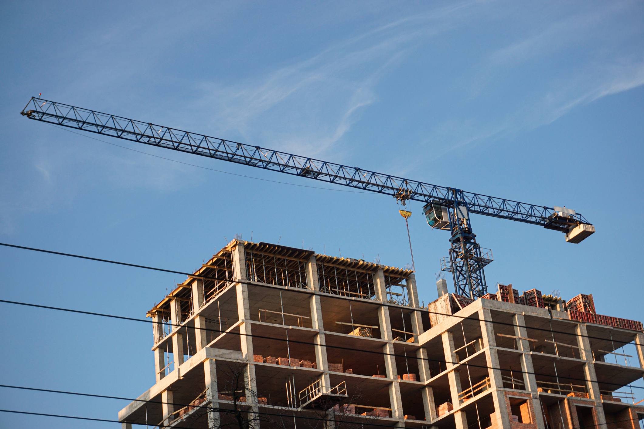 A crane and a construction project against a blue sky