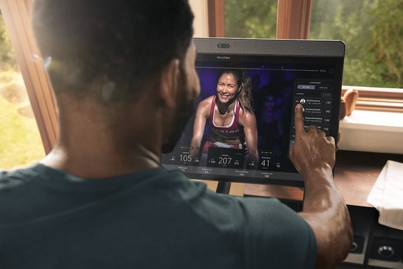 A man prepares to exercise with a Peloton Bike.