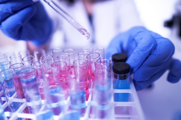 Someone transferring liquid into vials in a lab