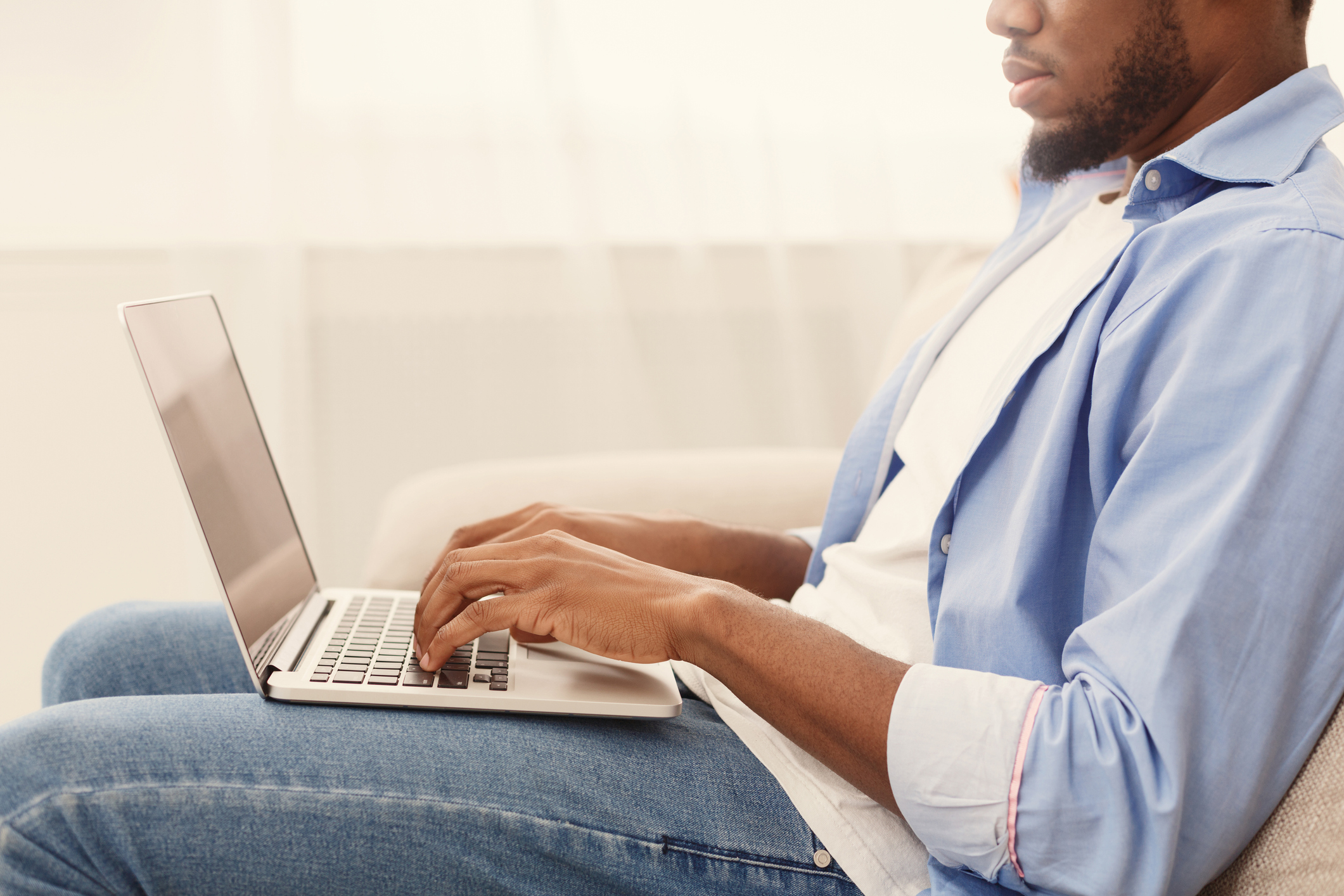 A man using a laptop while sitting.