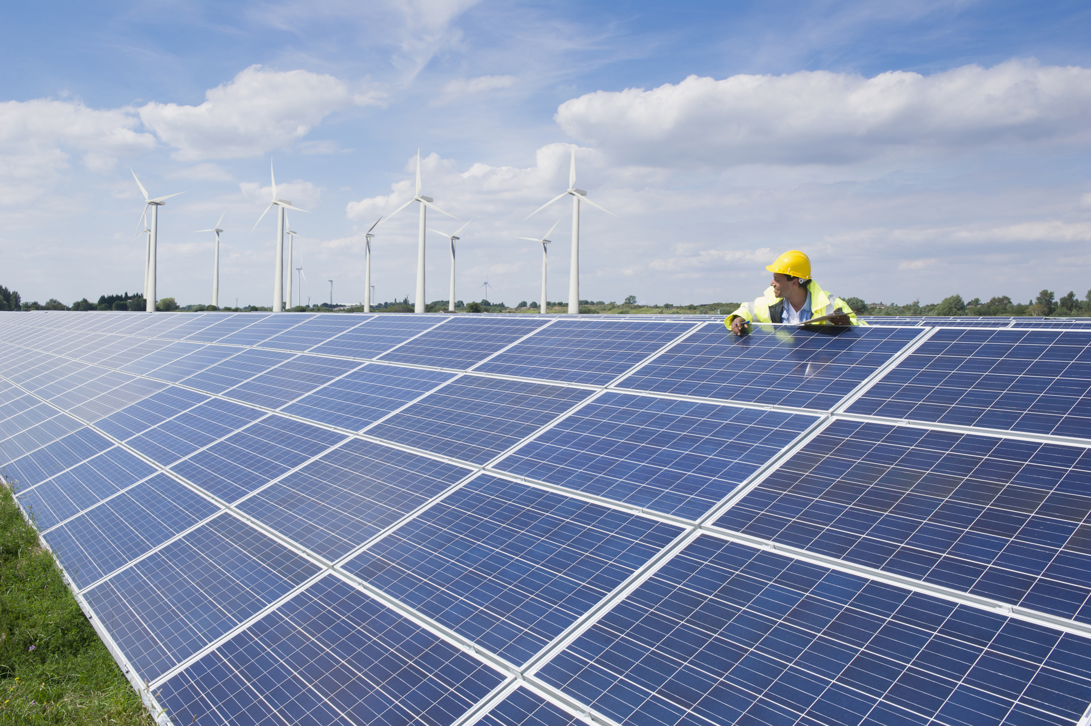 Solar panels, windmills, and a worker.
