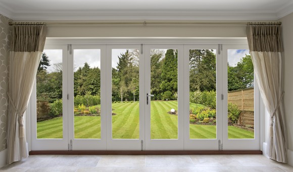 A wall with sliding doors leading to a garden.