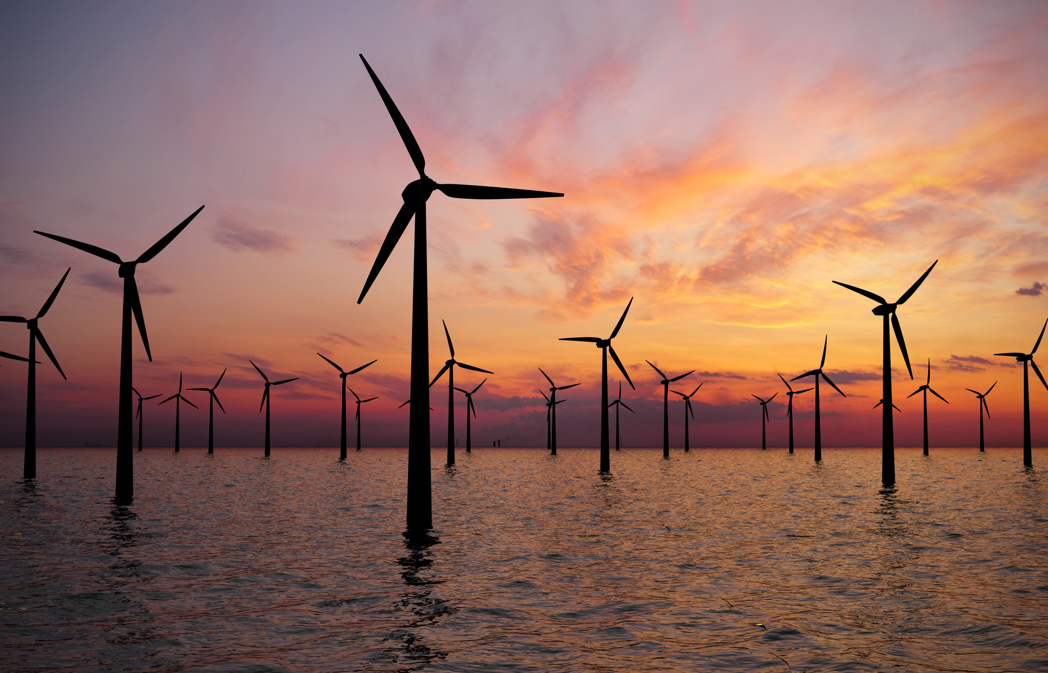 Offshore wind turbines at sunset.