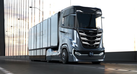 A Nikola Tre, a Class 7 electric semi truck, shown pulling a trailer on a highway. 