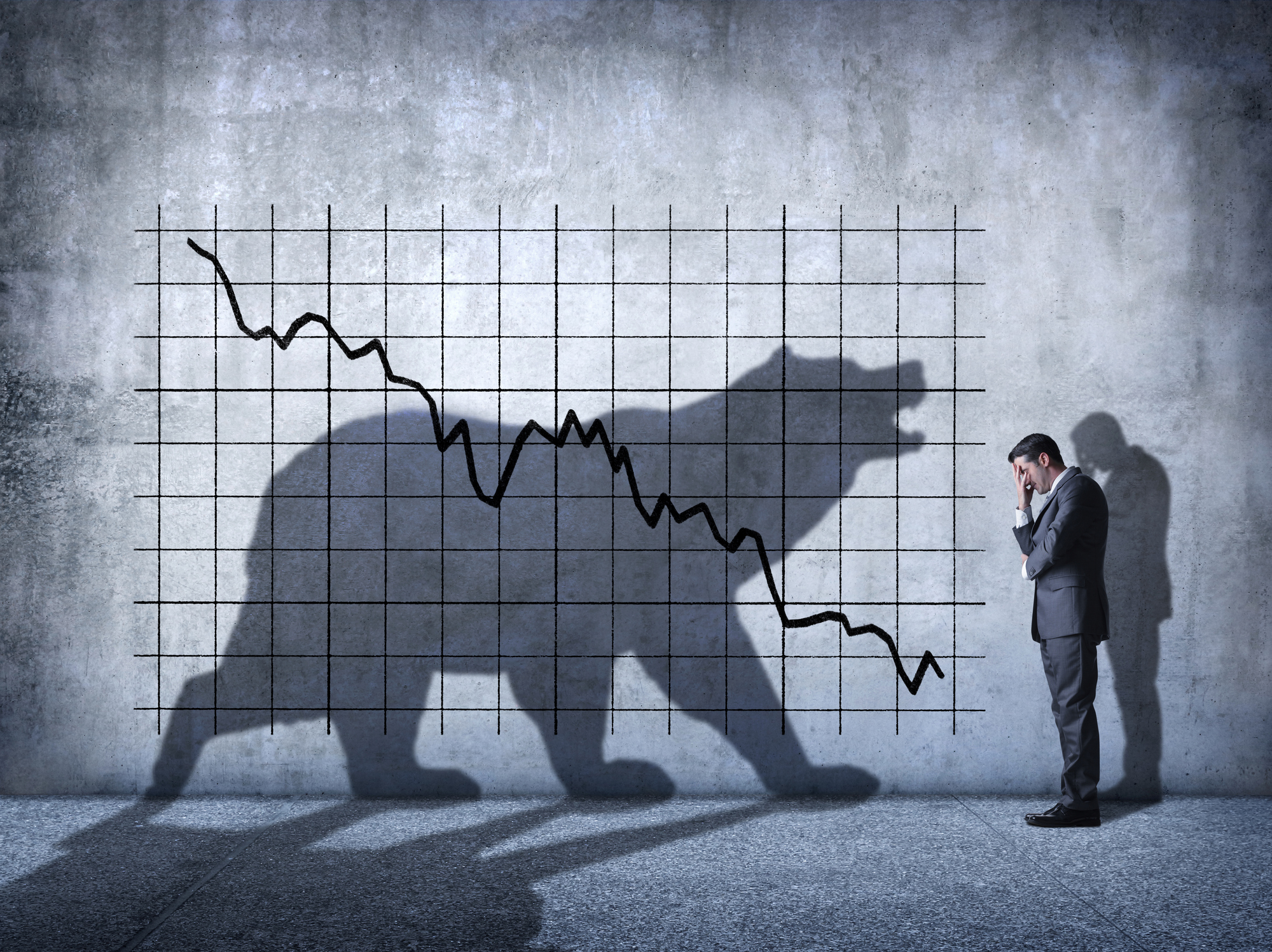 Downward-sloping stock market chart with a shadow of a bear in the background