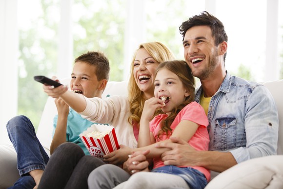 A family watching TV while sitting on a couch.