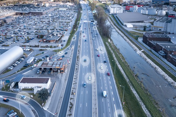 A highway with vehicles that have a bubble surrounding them, representative of lidar technology. 