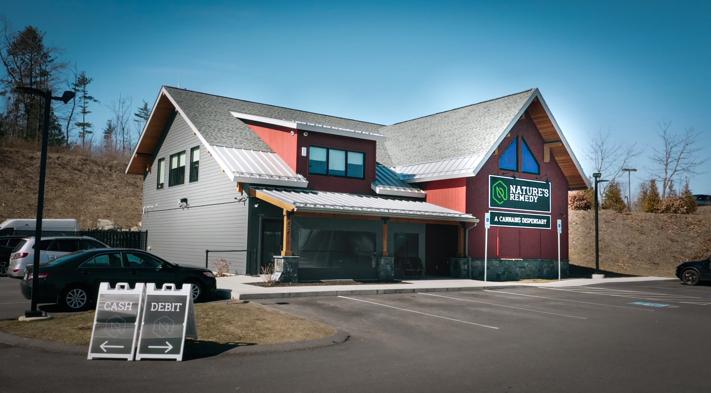 Nature's Remedy dispensary in Massachusetts, a small building with a sign out front that says "cash, debit."