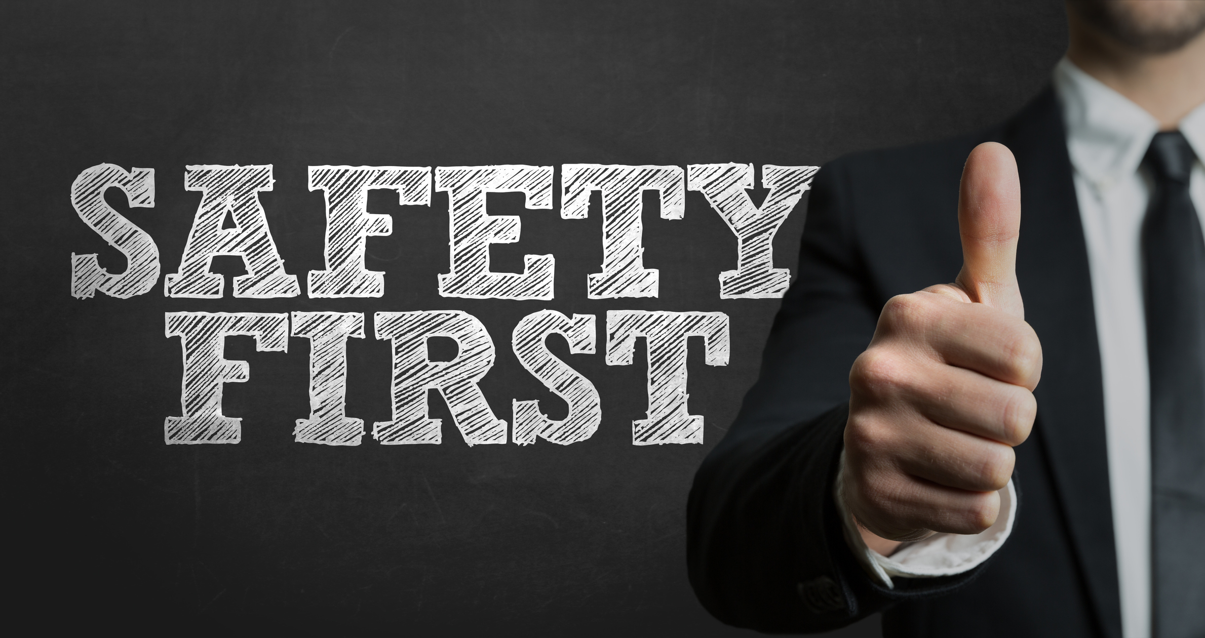 The words Safety First with man giving thumbs-up sign in the background.