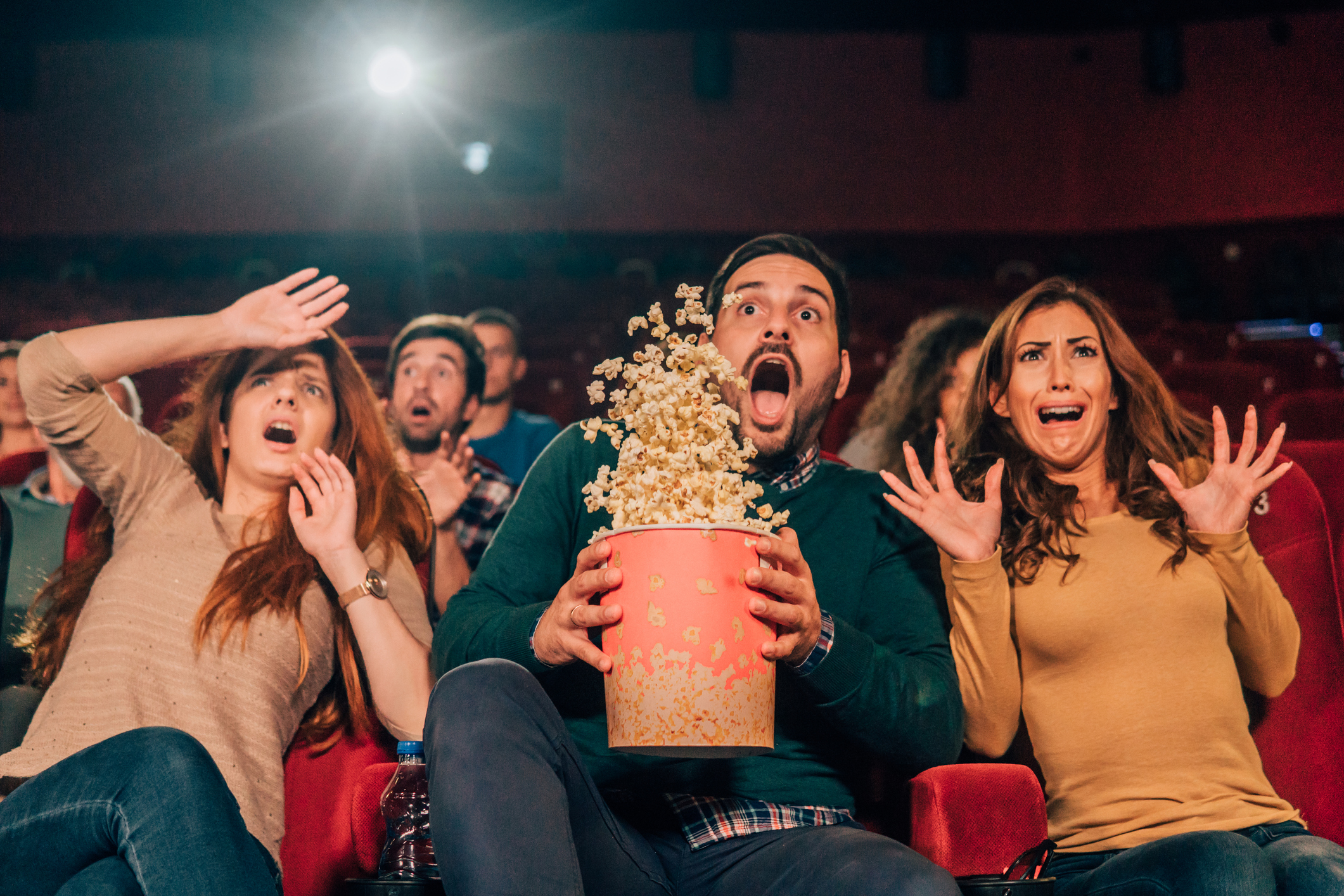 People in movie theater looking surprised