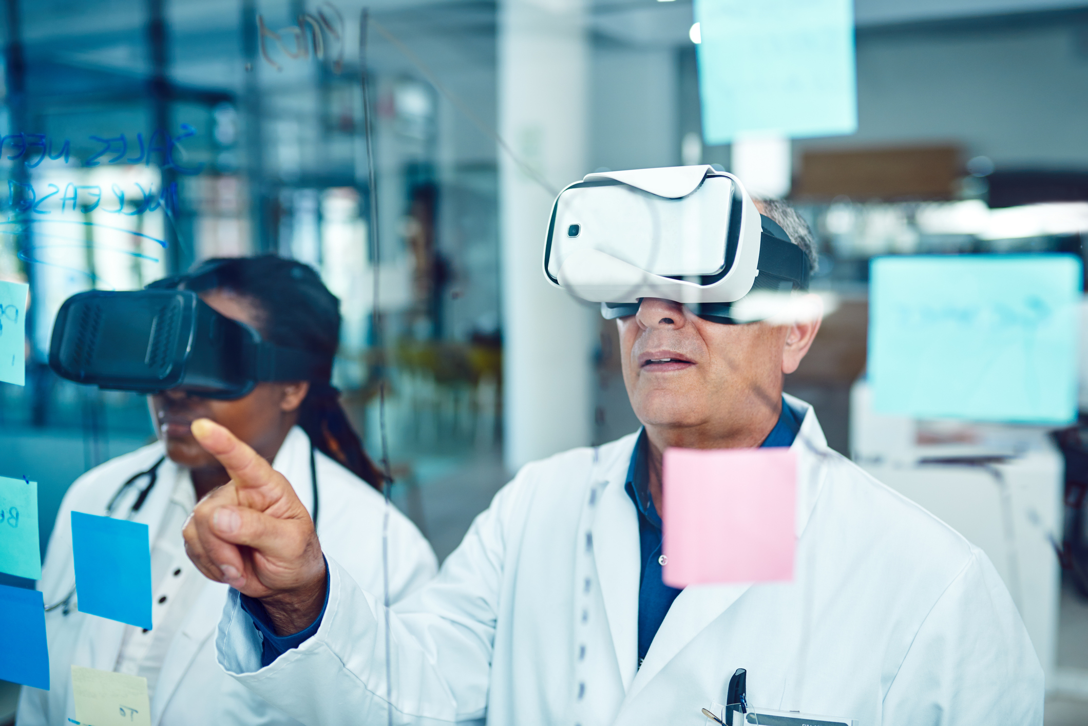 male and female doctor wear virtual reality devices over their eyes at work