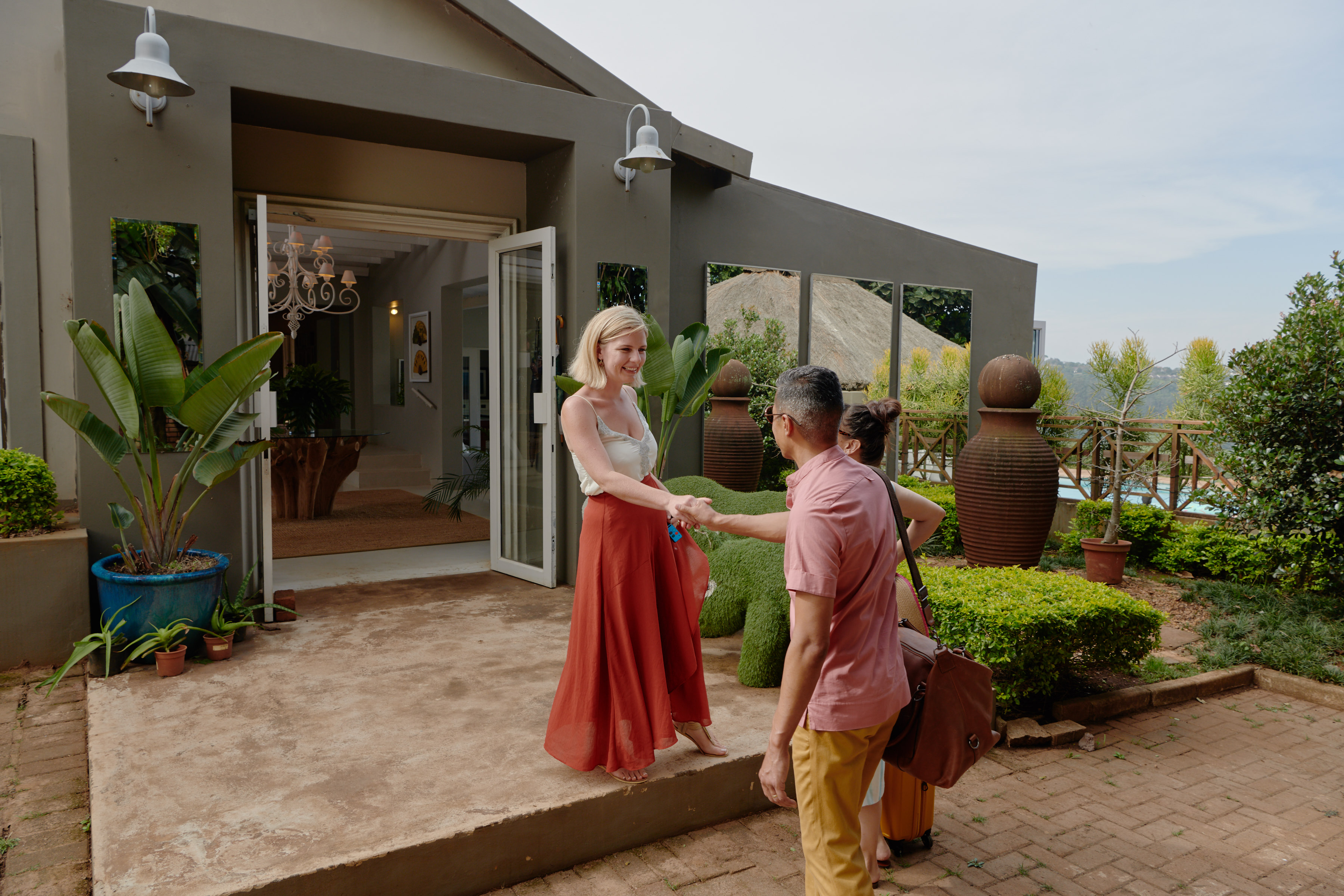 An Airbnb host greets her guests at her home.