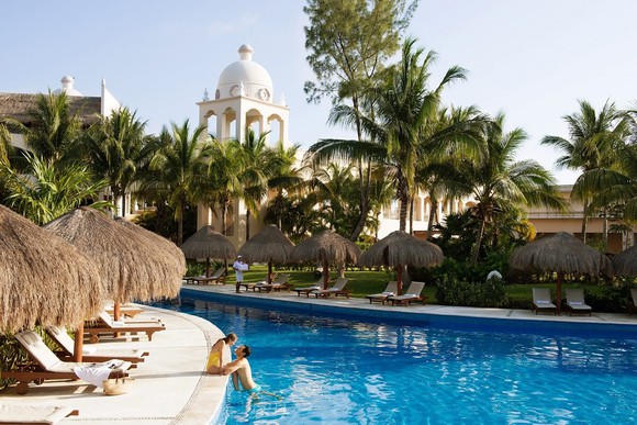 A couple enjoying a pool at a resort.