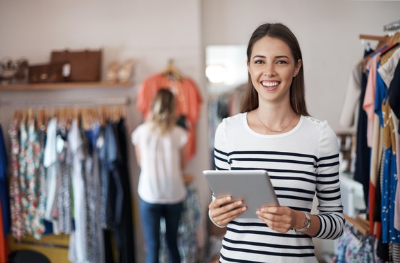Woman holding tablet in clothes store