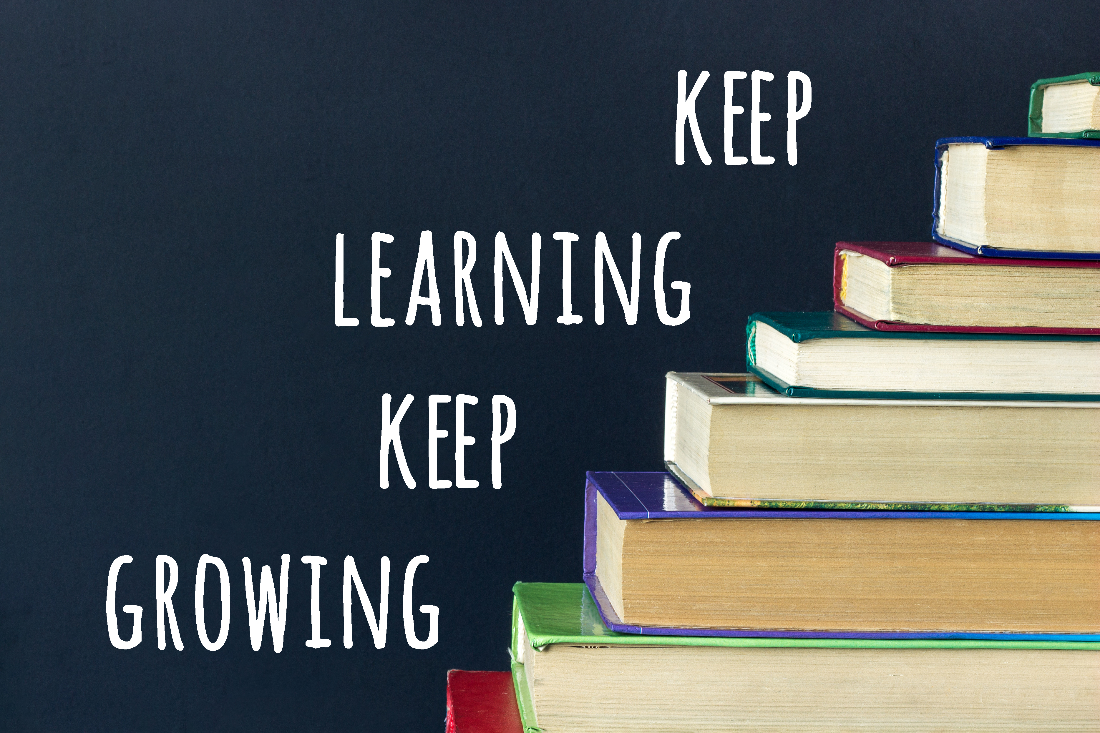 Next to a stack of books are the words keep learning keep growing.