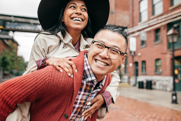 Person happily gives piggy back ride to a friend