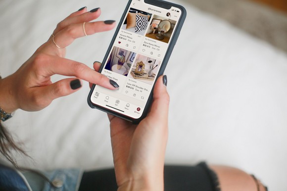 A woman browses Poshmark's mobile app.