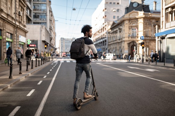 Man riding an e-scooter in a city