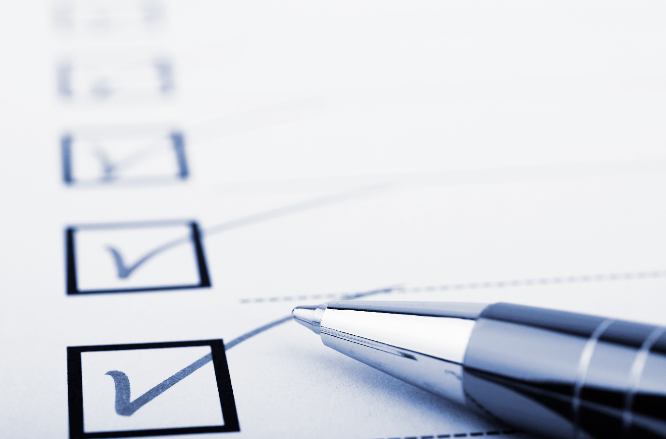 Multiple boxes checked on a checklist, with a pen lying atop the list.