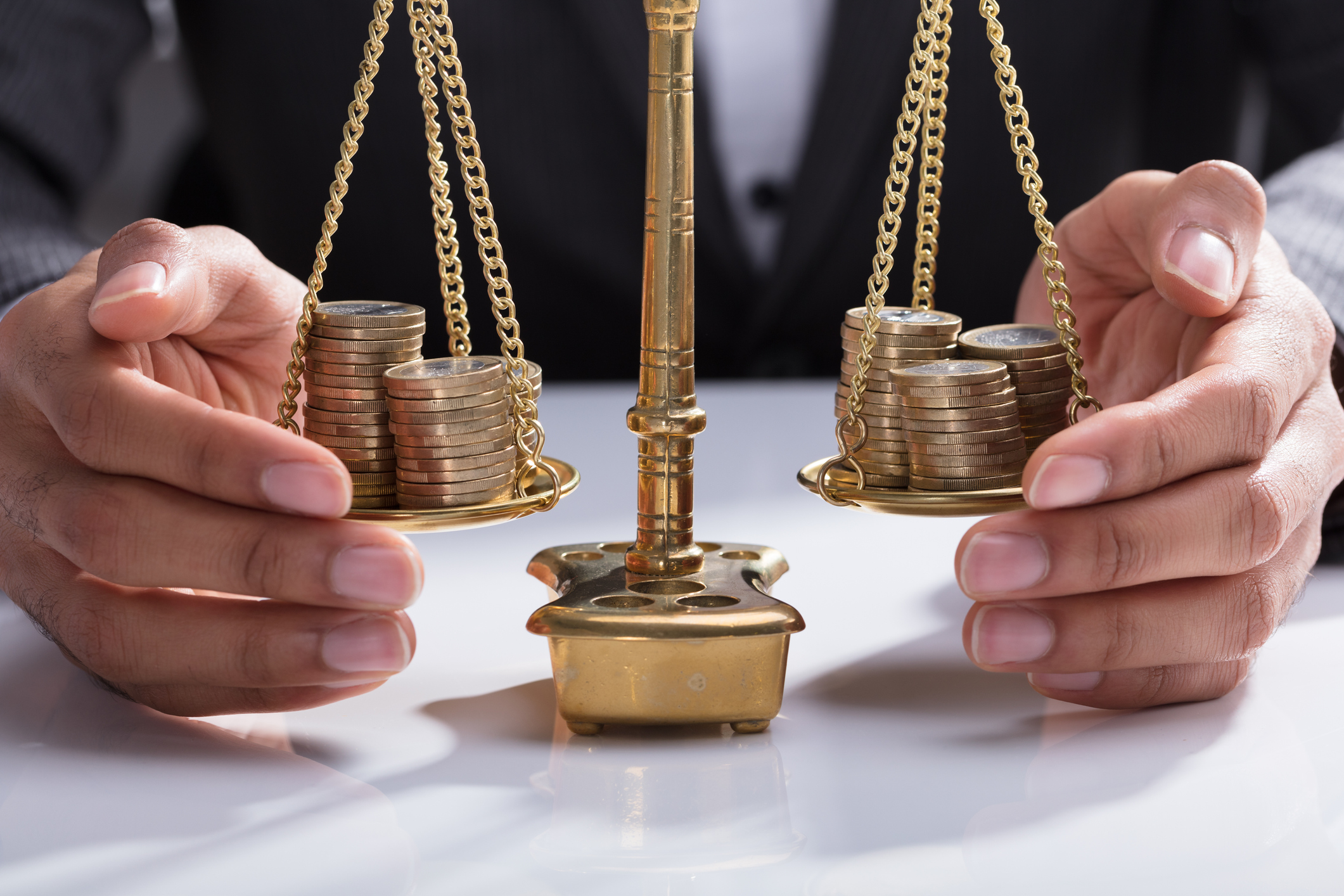 Scales with two stacks of coins on them.