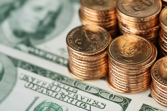 Hundred-dollar bills and stacks of gold coins.