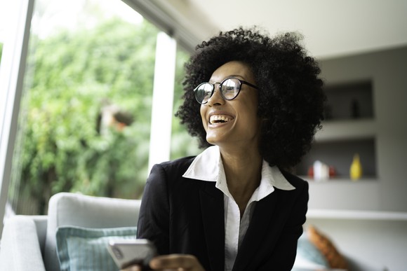 A business woman looking off to the side, smiling, as if she heard good news. 