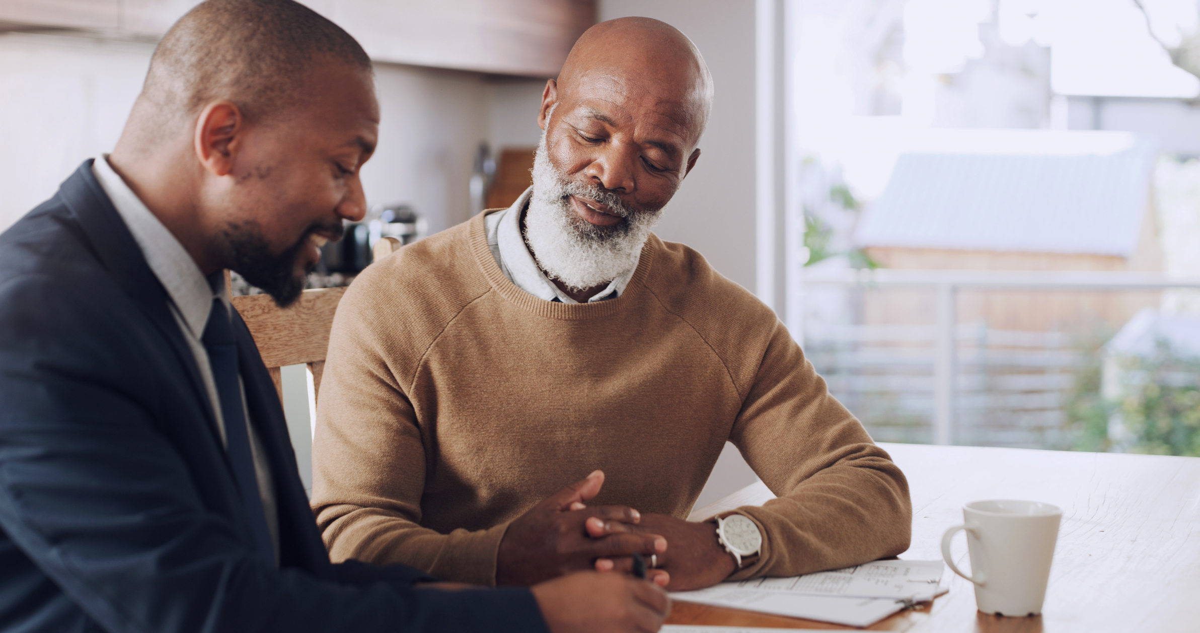 A person works with a financial advisor in a kitchen.