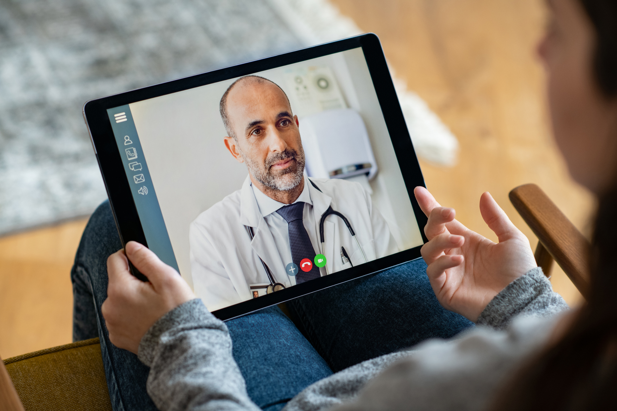 A person using a tablet to speak virtually with a physician.