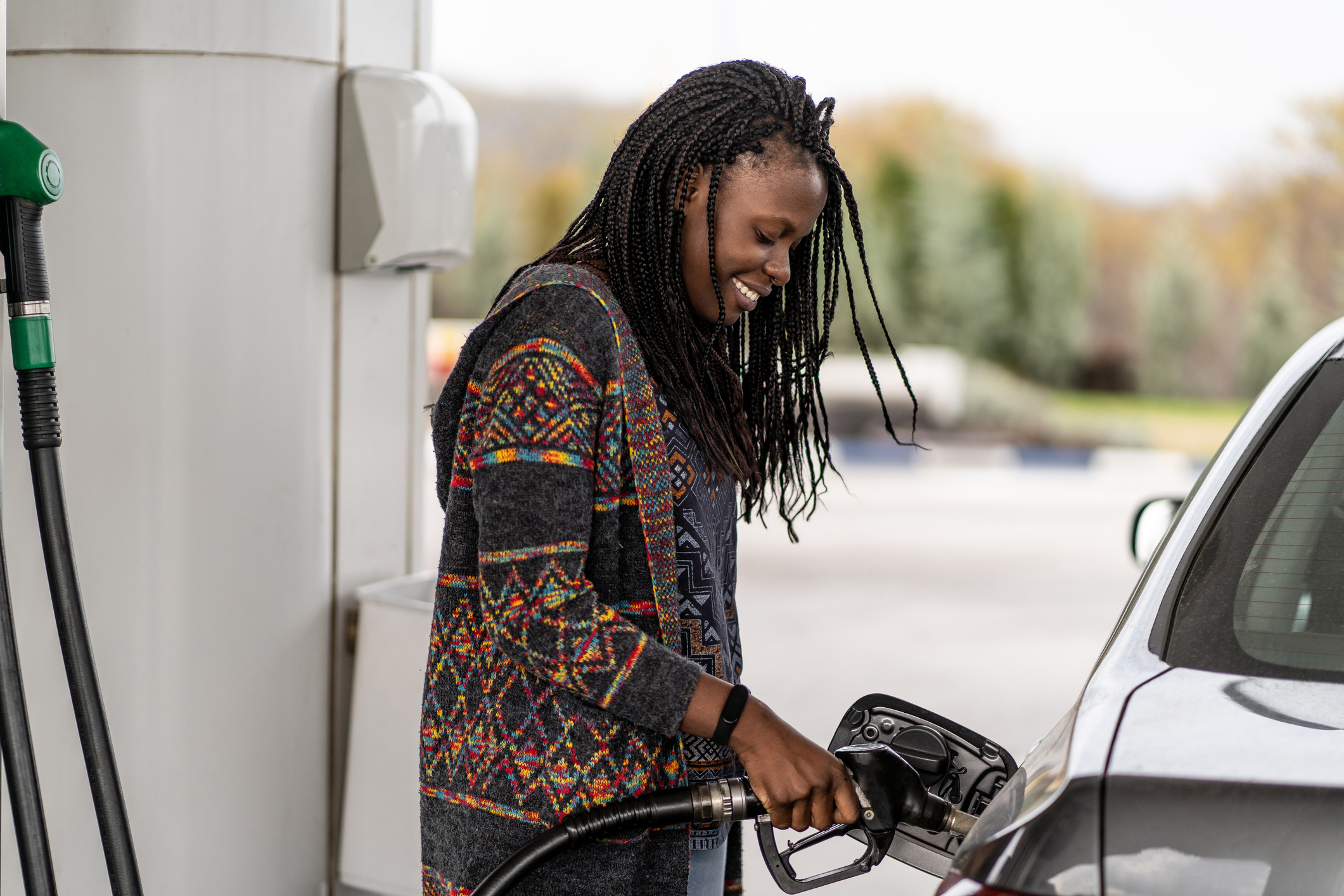 Person refueling a car at a gas station pump.