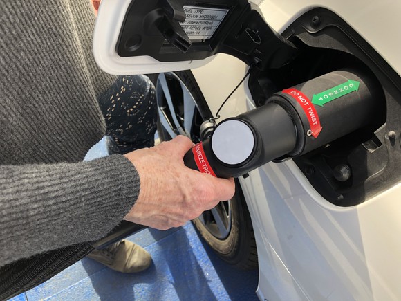 A person fueling a hydrogen-powered vehicle.
