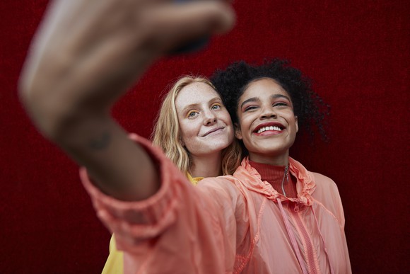 two friends smiling and taking selfie together