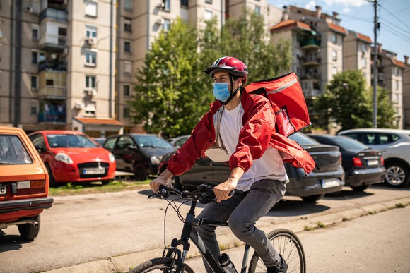 A courier delivers a meal on a bicycle.