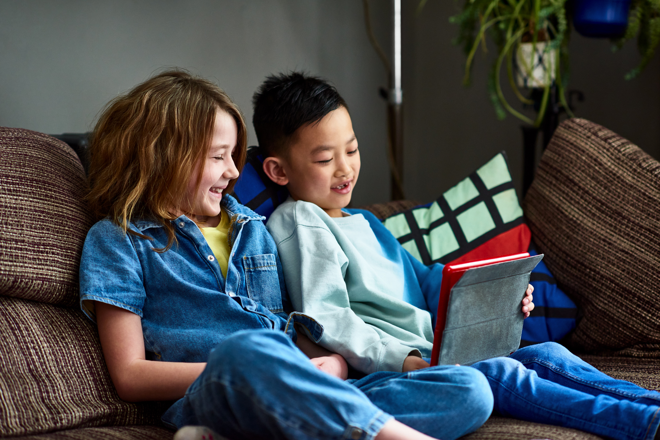 Two kids looking at a tablet.