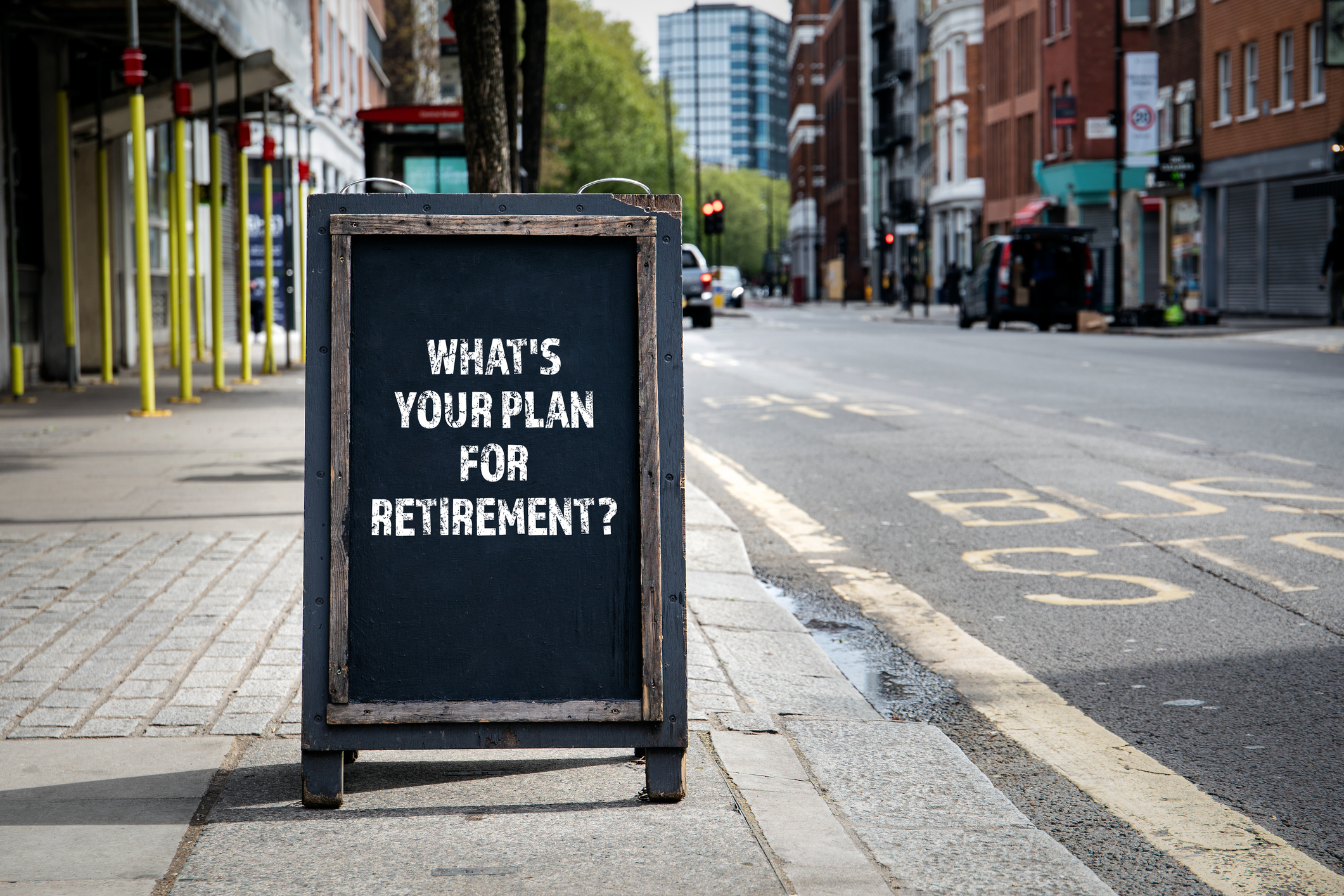 Chalkboard sign on a city sidewalk that reads what's your plan for retirement?