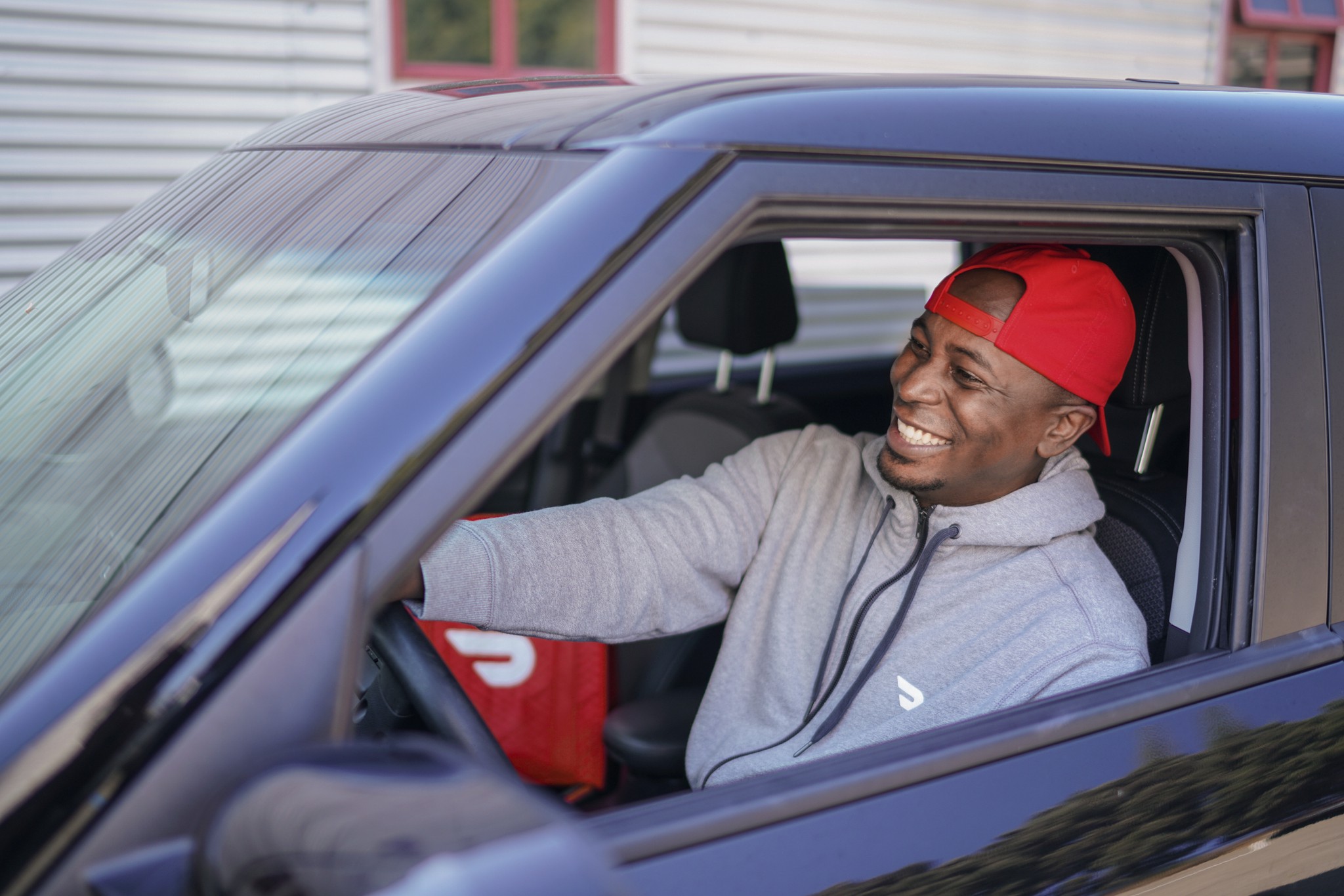 A Dasher picks up an order in a car.