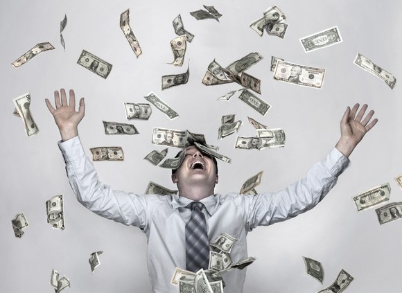Man standing amid flying money bills.
