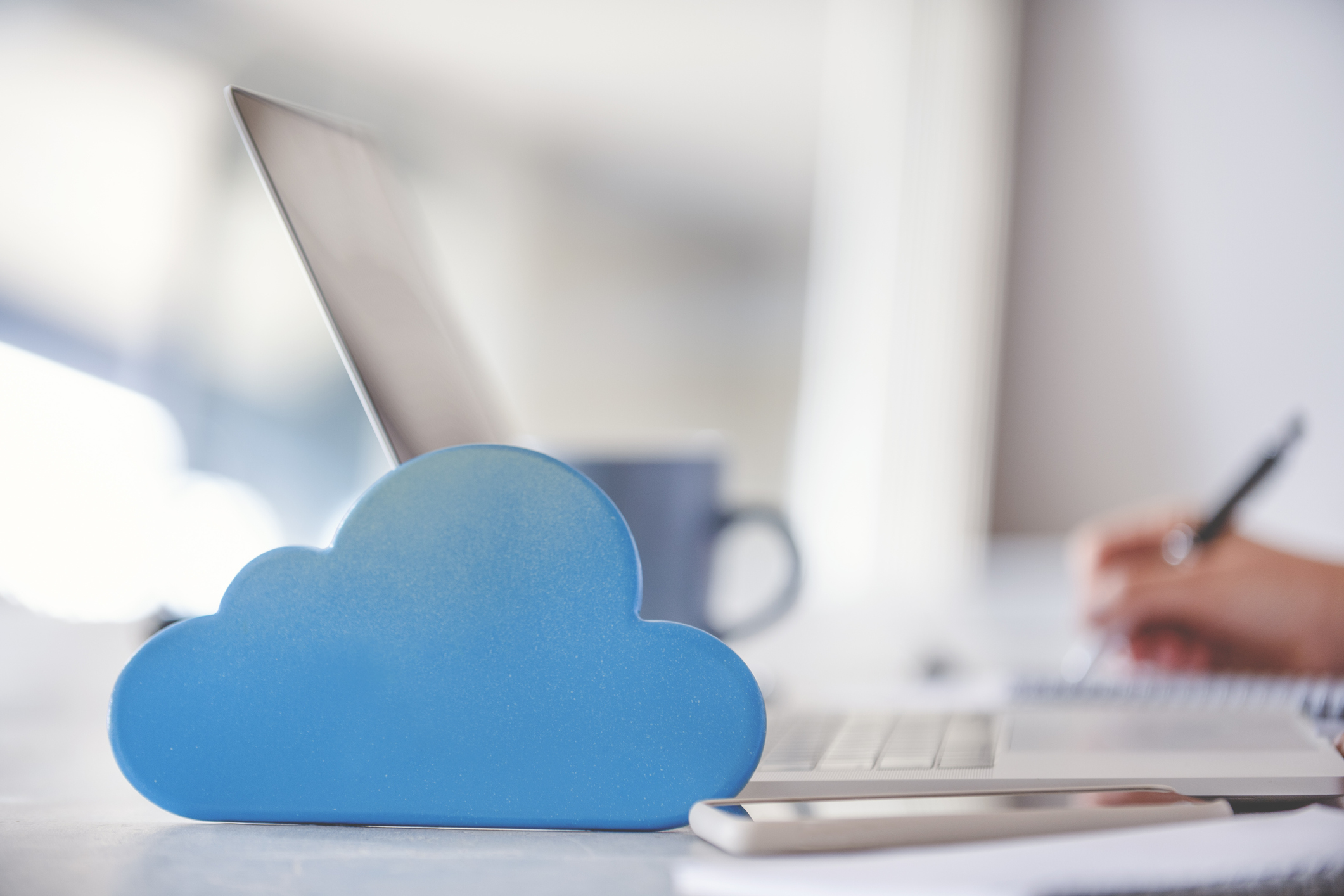 A cloud icon placed next to a notebook computer.
