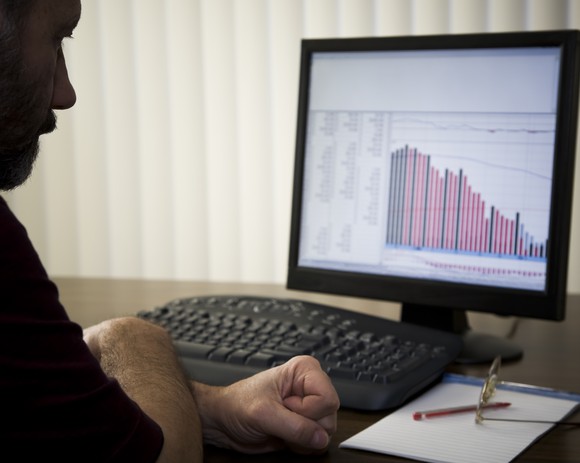 Investor looking at a sinking stock chart.
