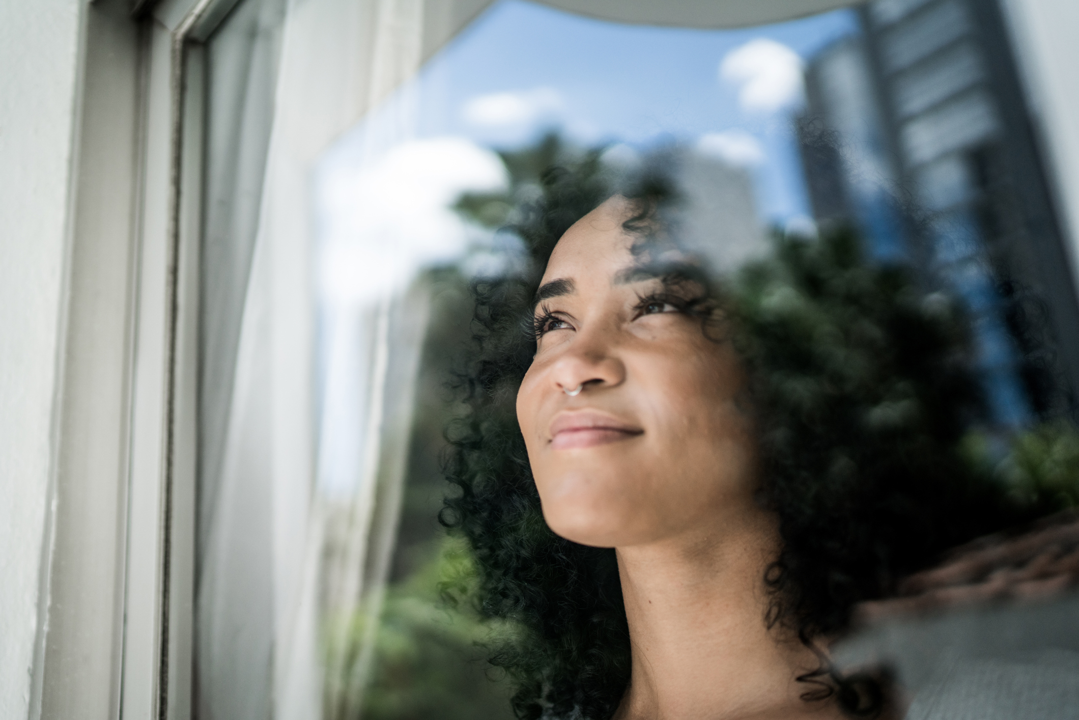 optimistic woman looks out window