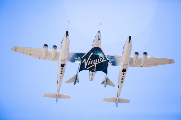 Virgin Galactic's mothership and spacecraft flying with a blue sky. 
