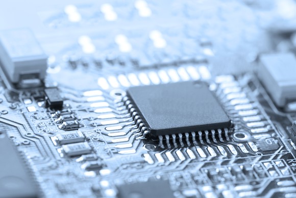 A black and white photo of a processor on a printed circuit board. 