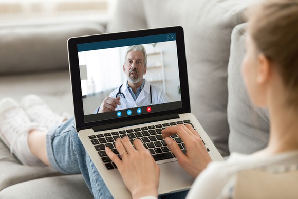 Young woman chatting with a physician during a virtual checkup.