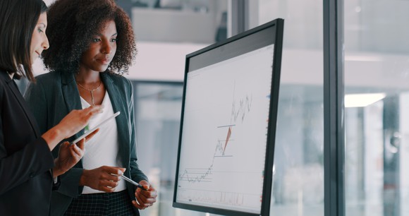 Two people analyzing a chart.