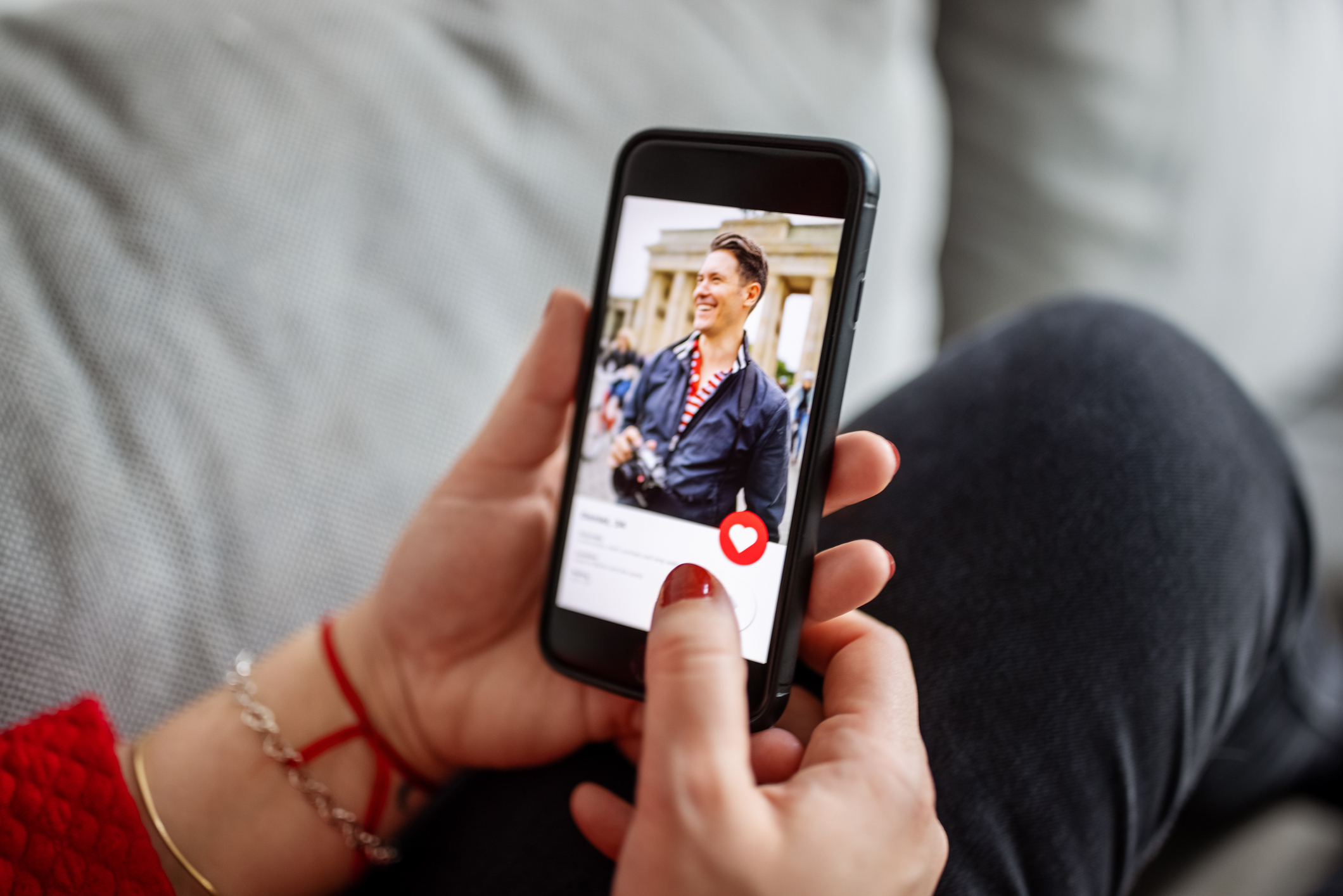 Person clicking on a dating app on a smartphone.