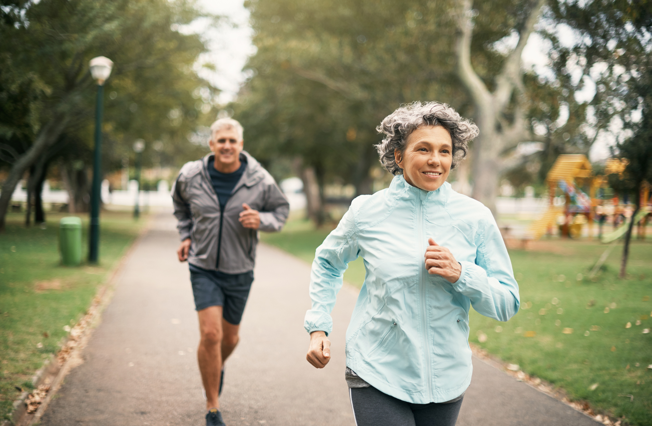 Two seniors running outdoors.