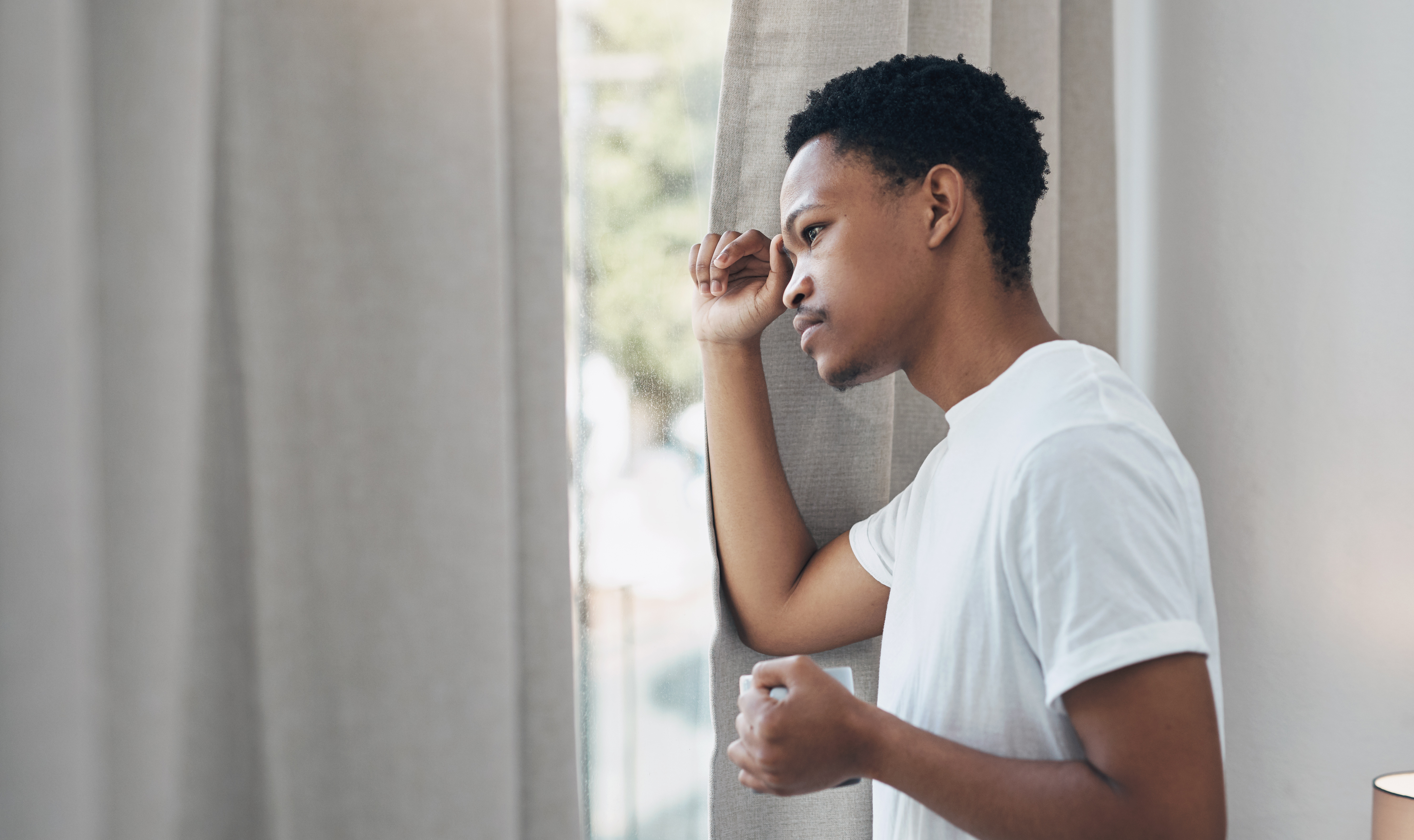 Person looking out window missing out on party having FOMO