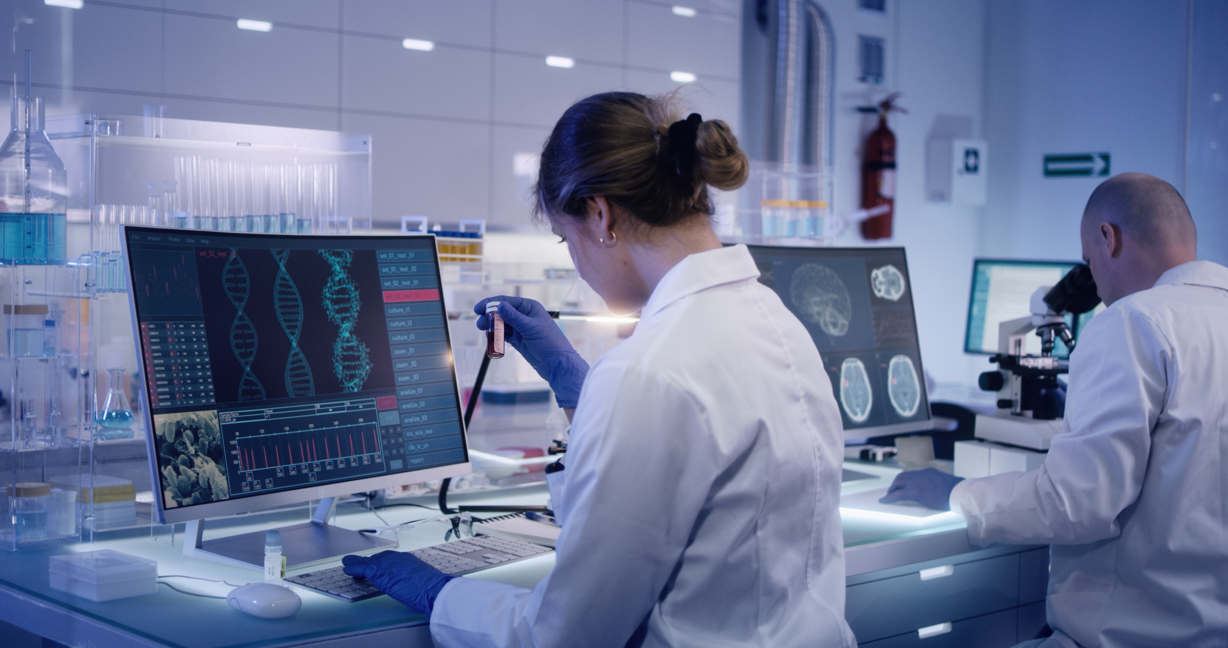 Two scientists analyze genetic data in a lab.